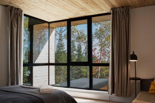 拉马巴耶Le Ruisseau: luxurious villa in Charlevoix.的一间卧室设有美景大窗户