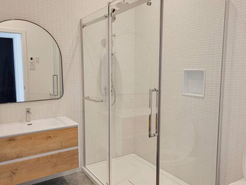 拉马巴耶Le Ruisseau: luxurious villa in Charlevoix.的一间带玻璃淋浴和水槽的浴室