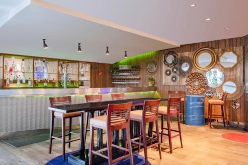 多哈多哈市中心马奎斯万豪酒店的餐厅设有1间带椅子和镜子的酒吧