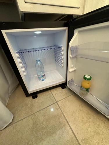 那不勒斯B&B Pantarei Napoli的配有一瓶水和两杯饮料的开放式冰箱