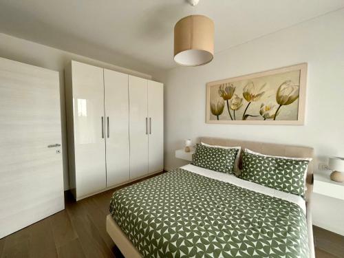 佩罗Stupendo appartamento in Fiera Milano-Up Town的卧室配有一张床,墙上挂有绘画作品