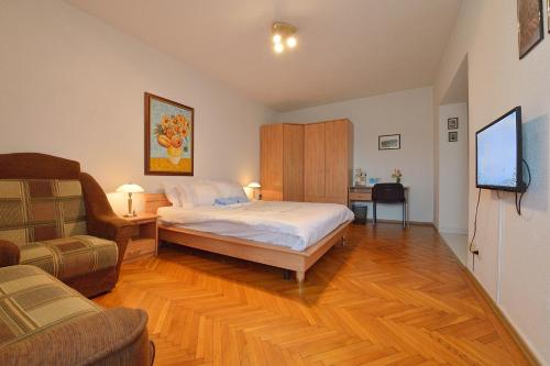 布加勒斯特阿特拉斯罗马力士一室公寓酒店的一间卧室配有一张床、一台电视和一张沙发