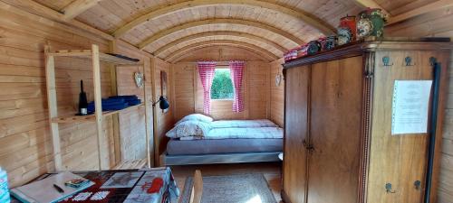 MörlenbachUrlaub im Bauwagen的小木屋内的小房间,配有一张床