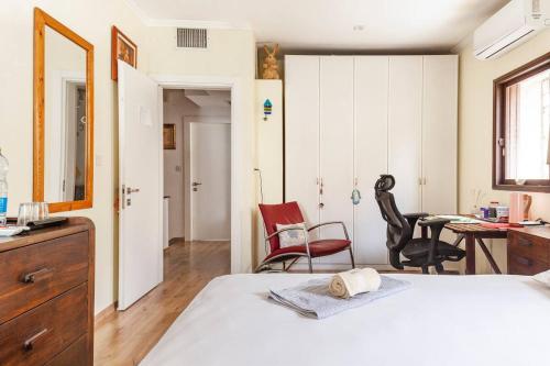 荷兹利亚Cosy room near IDC & Center- Herzliya Homestay的卧室配有一张床、一张桌子和椅子