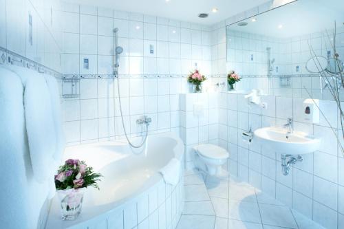 基尔基尔坎帕尼莱阿斯特酒店的白色的浴室设有浴缸、卫生间和水槽。
