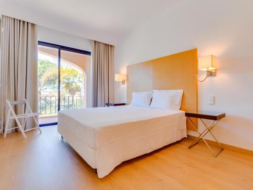 维拉摩拉AL - Apartamento Vila Sol AG的一间卧室设有一张大床和一个大窗户