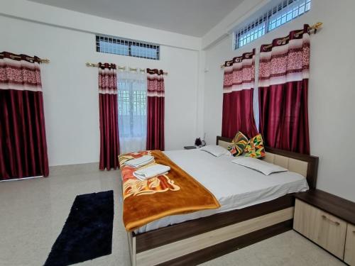 TezpurPurabi's Nest的一间卧室配有红色窗帘的床