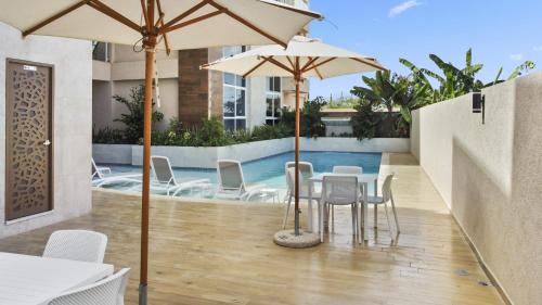 棕榈滩Bocobay Aracari Condo Hotel的一个带桌椅和遮阳伞的庭院