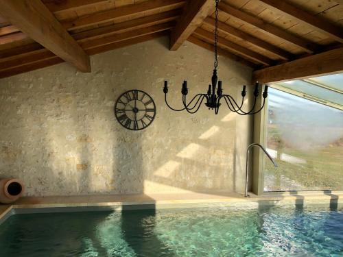 TerraubeMaison du bonheur的吊灯挂在游泳池旁边的墙上