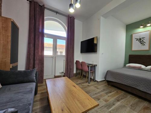 苏科尚萨娜公寓的客房设有床、沙发和桌子。