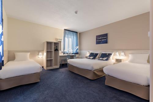 梅斯ACE Hôtel Metz的酒店客房配有两张床和一张书桌