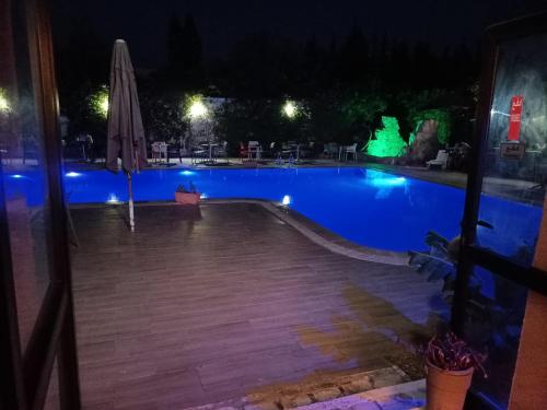 苏塞Hotel Diar Meriam的夜间游泳池,带遮阳伞