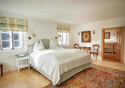 阿尔陶塞Luxuriöses Bauernhaus in Seenähe的卧室配有一张白色的大床和一张桌子