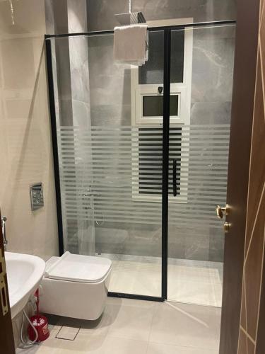 利雅德Al Narjes Villas & Apartments的带淋浴、卫生间和盥洗盆的浴室