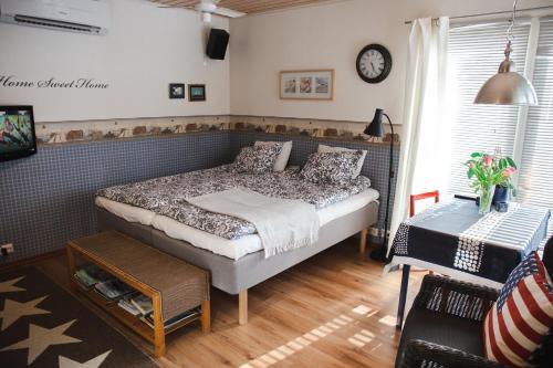 科科拉Erillinen ilmastoitu vierassviitti, Kokkola的卧室配有一张床,墙上挂着一个钟