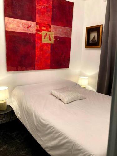 索米耶尔Appartement à Sommières的卧室配有一张白色床,墙上挂有绘画作品