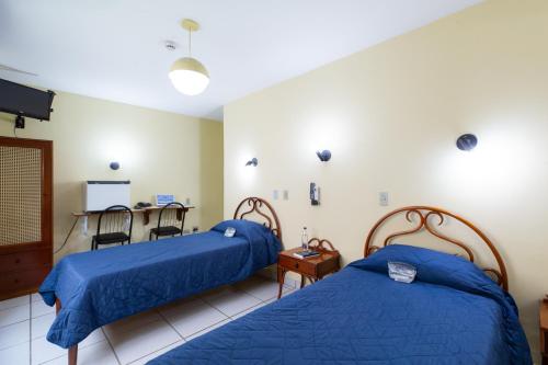 圣保罗Daher Center Hotel的一间医院间,配有两张床和一张桌子