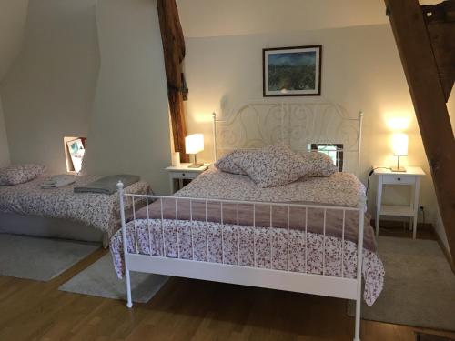 Épeigné-les-BoisLa Lézardière的一间卧室配有一张床、两张桌子和两盏灯。