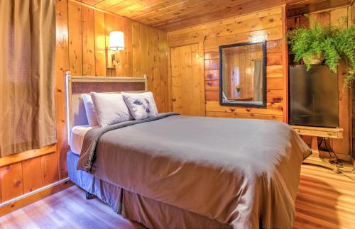 萨利达Lodge at Poncha Springs的一间卧室设有一张床、一台电视和木墙