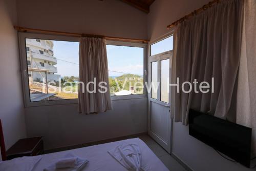卡萨米尔Islands View Hotel的客房设有窗户、一张床和一张桌子