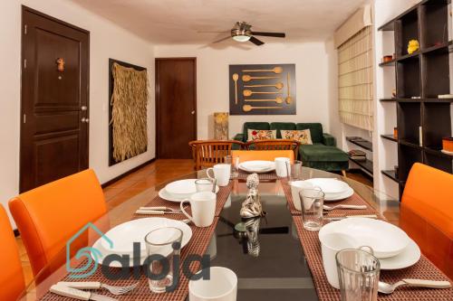 坎昆Apartamento amplio en zona ideal a 5min de WALLMART的一间带桌子和橙色椅子的用餐室