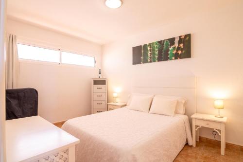 阿德耶Roque del Conde Seaview的一间白色卧室,配有两张床和两盏灯。
