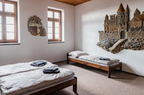 特普利采Penzion hrad Doubravka的墙上挂着城堡壁画的客房内的两张床