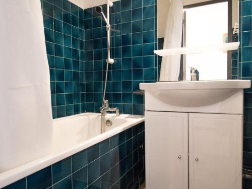 琴山朗勒堡Appartement Lanslebourg-Mont-Cenis, 2 pièces, 4 personnes - FR-1-508-71的蓝色瓷砖浴室设有浴缸和水槽