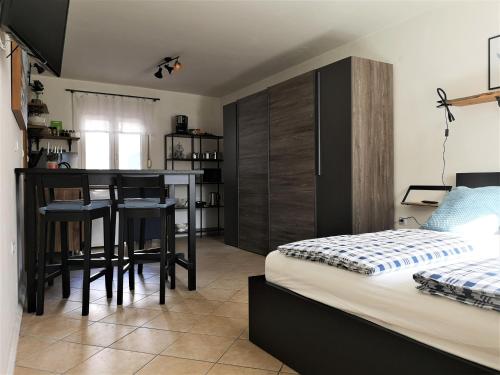 博维茨Apartmaji Prton Bovec的一间卧室配有一张床,厨房配有桌子