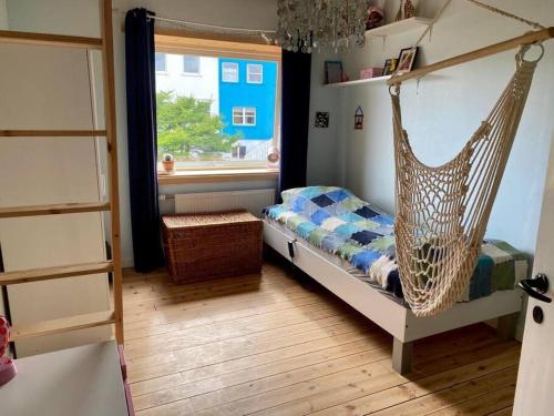 托尔斯港Newly renovated house with garden and ocean view的卧室配有秋千床和窗户。
