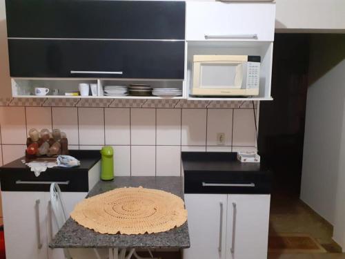 阿拉索亚巴达塞拉Chácara com Piscina的带微波炉和桌子的小厨房