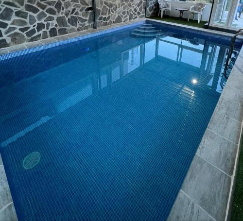 马拉加Casa Rural El Castillo的一座铺有蓝色瓷砖地板的大型游泳池