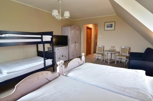 瓦乌布日赫新村旅馆的一间卧室设有两张双层床和一张桌子