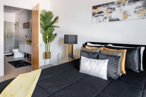 夏洛特Luxurious & Comfy Downtown Oasis ~ Views ~ Parking的一间卧室配有一张带枕头的大型黑色床。
