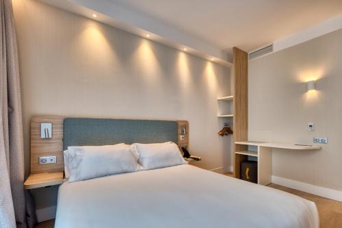 马德里Holiday Inn Express - Madrid - Airport, an IHG Hotel的卧室配有一张白色大床和一张书桌
