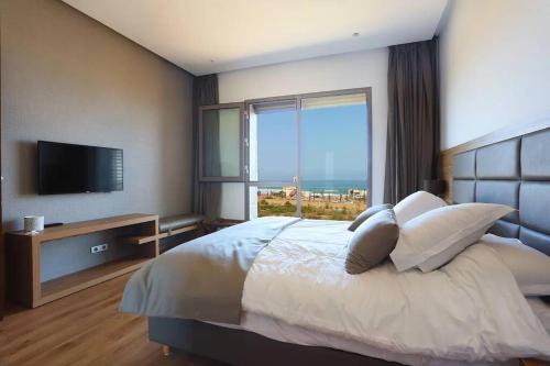卡萨布兰卡Luxury Apartment at Corniche , Seaview Close Beach的一间卧室设有一张大床和大窗户