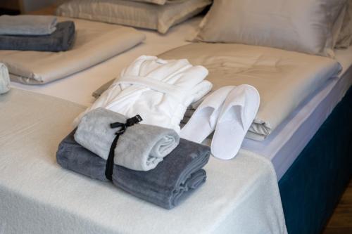 斯普利特West Coast Deluxe Rooms - Vacation Rental的床上有毛巾和鞋子