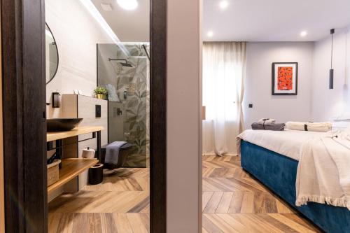 斯普利特West Coast Deluxe Rooms - Vacation Rental的一间卧室配有床、水槽和镜子