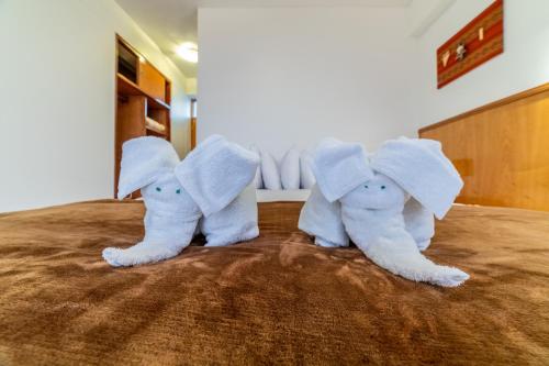 普诺Hotel Qalasaya的两头塞满大象的睡床上