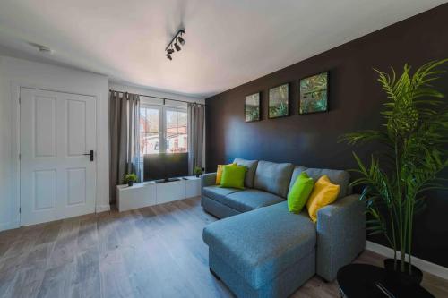 格拉斯哥ComfySleep ApartHOUSE的客厅配有蓝色沙发和绿色枕头。