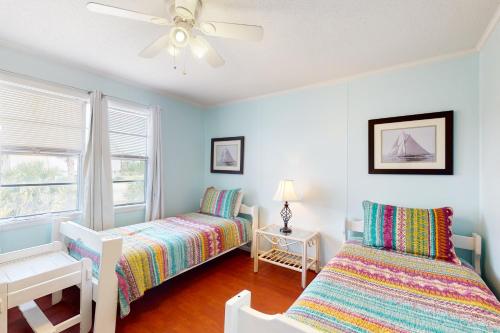 格尔夫海岸Abaco House的一间卧室配有两张床和吊扇