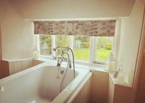 Hutton le HoleBurnley country house的带浴缸的浴室和窗户
