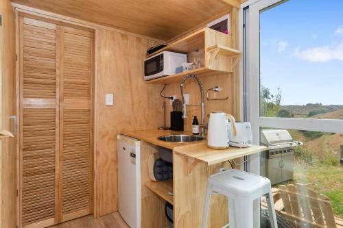 PukehinaRural Couples Retreat/Tiny House的一个小房子里的厨房,有窗户