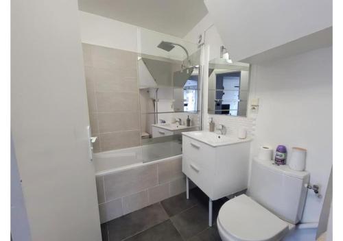 圣西尔-莱科勒Superbe appartement avec jardin proche Versailles的浴室配有卫生间、盥洗盆和浴缸。