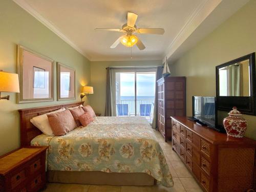格尔夫海岸Island Royale P403 by ALBVR - Beautiful Beachfront Penthouse Level Condo!的一间卧室配有一张带吊扇的床和一台电视。