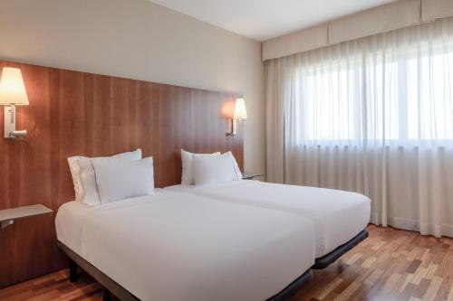 阿尔卡拉德荷那利斯AC Hotel Alcalá de Henares by Marriott的窗户客房内的一张大白色床