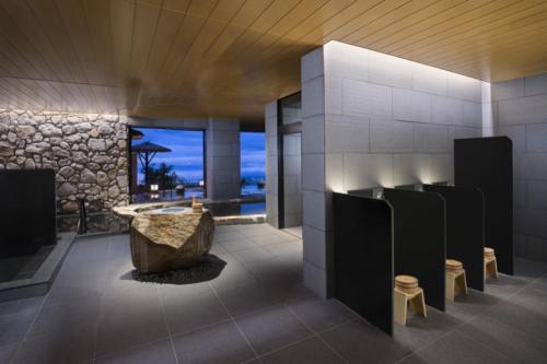 别府ANA InterContinental Beppu Resort & Spa, an IHG Hotel的带浴缸和石墙的浴室
