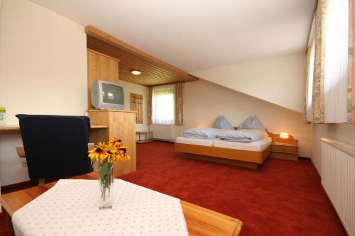 巴德米滕多夫斯佩克莫瑟尔旅馆的一间设有一张床和一张花瓶桌子的房间