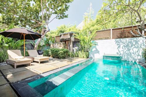 塞米亚克Mayaloka Villas的房屋旁的游泳池配有椅子和遮阳伞