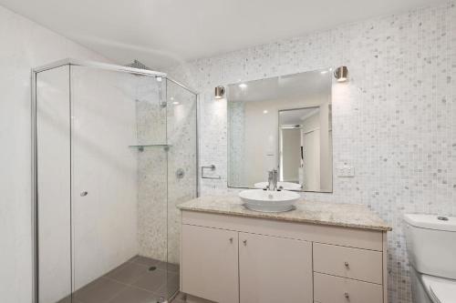 尼尔森湾拉曼街3/5号绿洲公寓的白色的浴室设有水槽和淋浴。